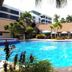 The Ritz Hotel at Garden Oases in Davao City: tropical outdoor pool with palm trees and poolside cabanas