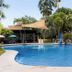 The Ritz Hotel at Garden Oases in Davao City features a tropical outdoor pool with palm trees and shaded lounge areas.