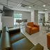 City Express by Marriott Lazaro Cardenas lobby with orange chairs, lounge seating, tables, and a breakfast bar