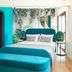 Colors Hotel Athens guest room with teal bed, tropical mural, and turquoise walls in Athens