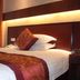 Yiwu Mango Hotel in Jinhua guest room with neatly made bed and patterned pillows