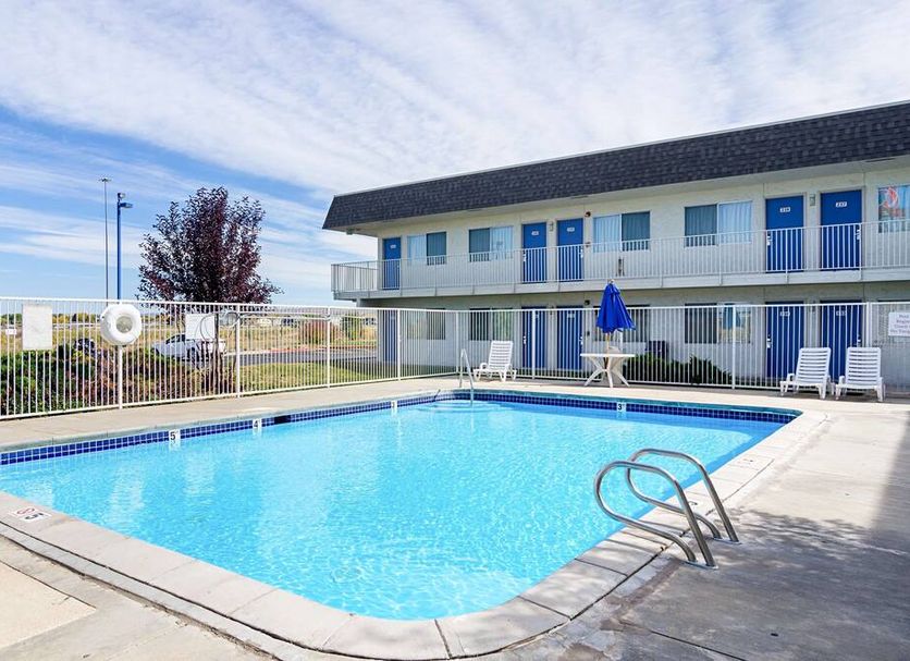 Motel 6 Laramie outdoor pool beside two-story motel building in Laramie