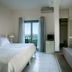 Kenta Beach Hotel in Agios Ioannis guest room with bed, sofa, and balcony view