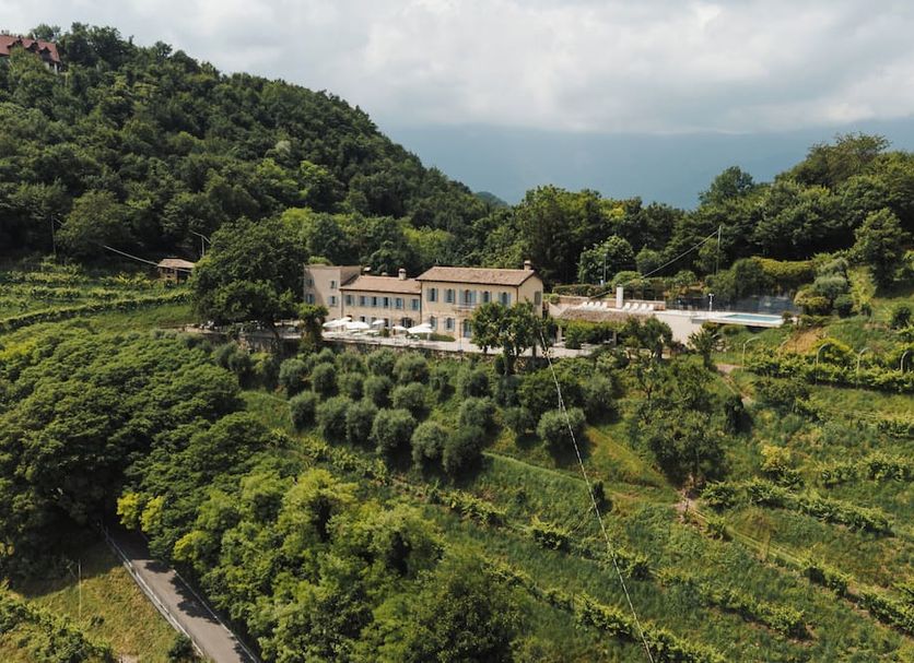 Locanda La Candola in Pieve di Soligo set amid lush hillside vineyards and forested mountains