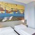 B&B Hotel Saarbrücken-Hbf room with twin beds and cityscape mural in Saarbrücken