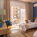 Hotel Aubi in Palamós guest room with twin beds, blue accent wall, and balcony door open to street view