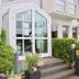 Hotel Garni Niedernhausen entrance with glass doors, steps, and landscaped greenery in Niedernhausen