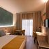 Ukino Palmeiras Village room in Porches with king bed, desk, chairs and balcony door