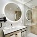 Sercotel Madrid Aeropuerto bathroom with walk-in shower, round mirror and modern sink in Madrid