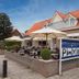 Outdoor terrace at Fletcher Hotel Restaurant De Gelderse Poort in Ooij with umbrellas and seating
