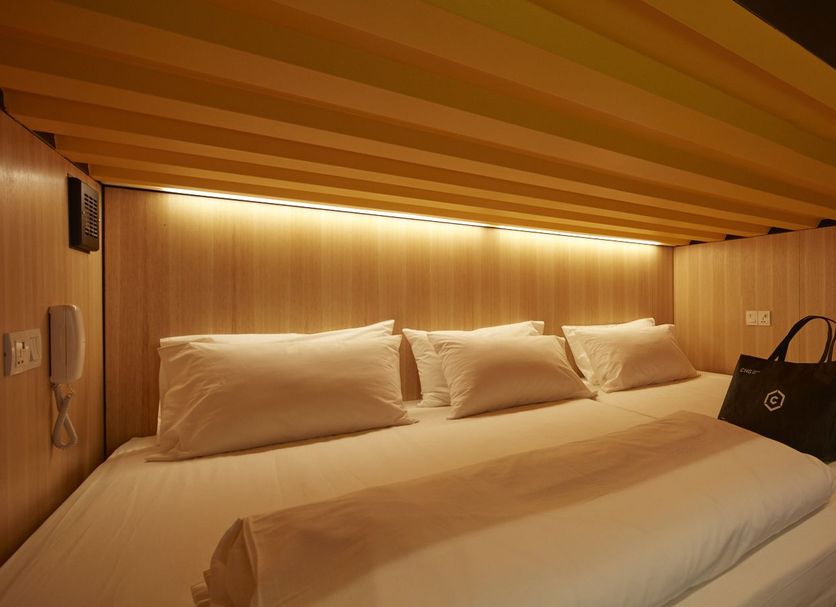 Capsuletransit Landside Airport Hotel in Sepang, capsule sleeping pod with twin bed and warm lighting