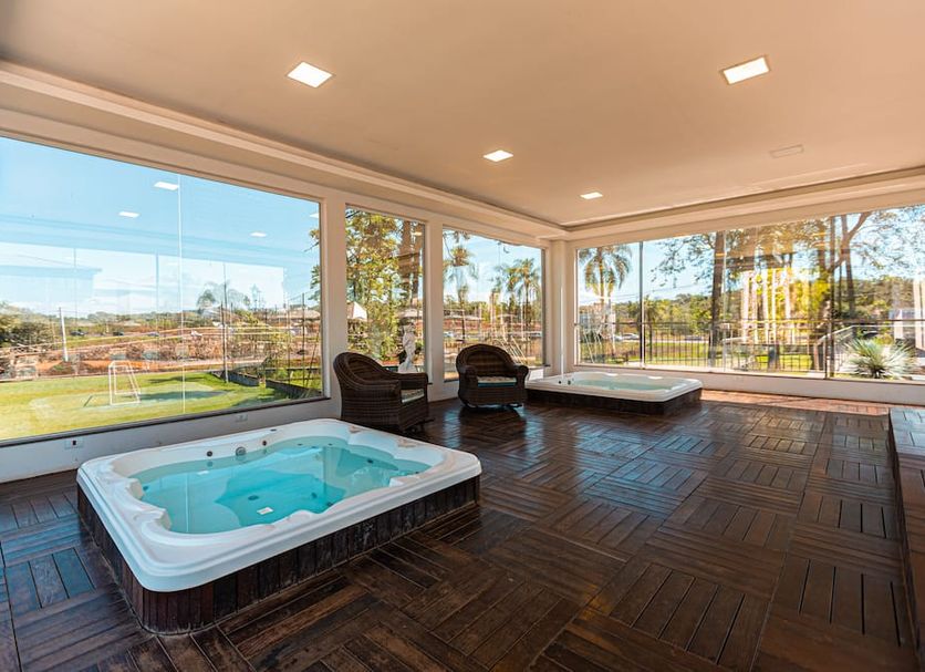 Grand Carimã Resort & Convention Center in Foz do Iguaçu: indoor hot tub room with large windows and garden views