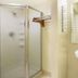 Super 8 by Wyndham Ashland/Richmond bathroom with frosted glass shower and wall-mounted sink