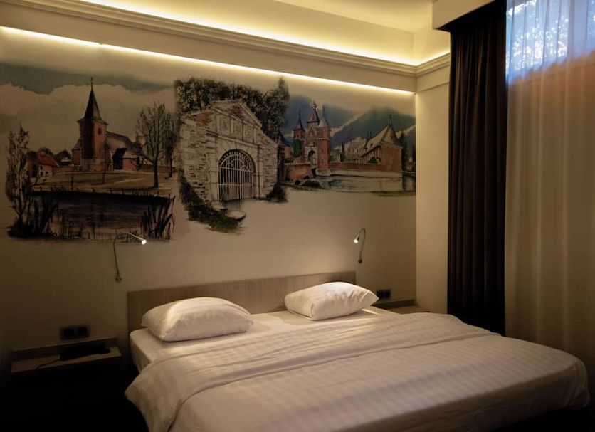 Blanckthys Hotel Voeren room in Gravenvoeren with twin bed, mural wall art, and sheer curtain window