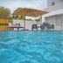 Casa Toñita in Levittown: outdoor pool beside a patio with lounge chairs and umbrella