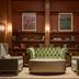 The Leo Kent Hotel, Tucson library lounge with green tufted sofa, armchairs and built-in bookshelves