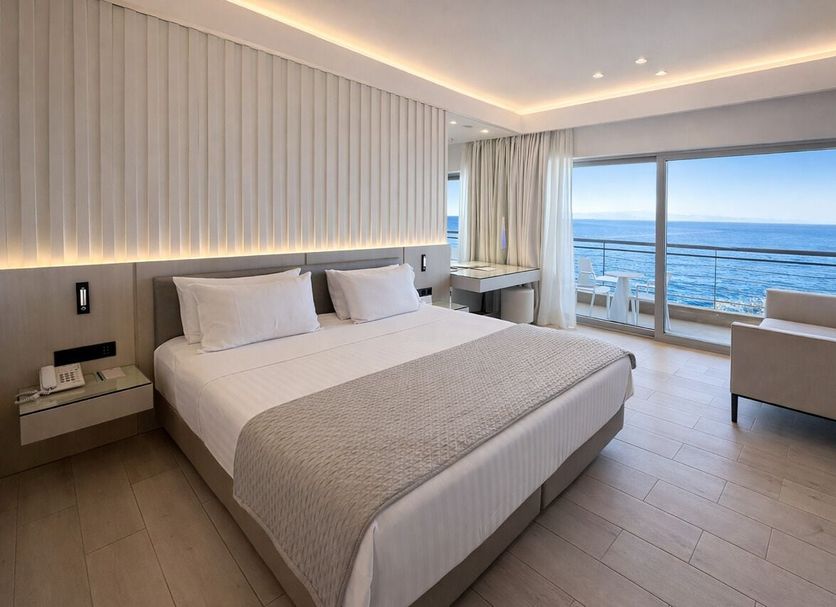 Mediterranean Hotel in Rhodes guest room with sea view, king bed, and balcony seating