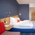 Holiday Inn Express Frankfurt Airport By IHG room with double bed, blue accent wall and desk in Mörfelden-Walldorf