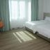 Citi Hotel Miri guest room with twin beds, desk, orange chair and sunlit window