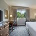 Delta Hotels by Marriott Waltham Abbey guest room with king bed, desk, and window view of greenery