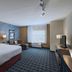 TownePlace Suites by Marriott Naples guest room with king bed, desk, seating area and window view
