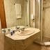 SHS Hotel Aeropuerto Madrid bathroom with sink, mirror and glass shower stall