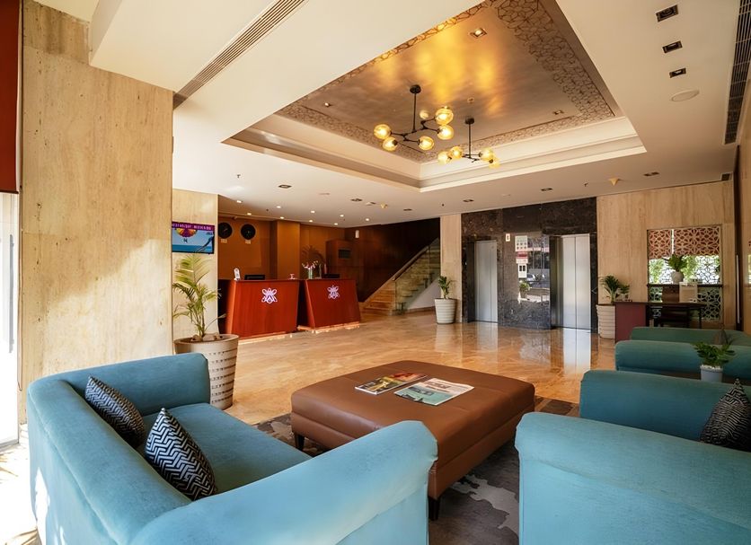 Royal Orchid Central Jaipur lobby with blue seating, reception desk, and staircase in Bani Park