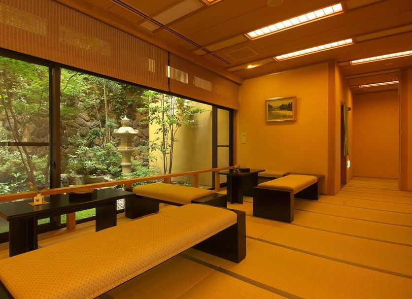 Ichinoyu Katei in Yamanouchi: tatami guest room with low beds and large windows overlooking a garden