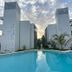 Aqua Resort in Diani Beach with a swimming pool between two modern white towers at sunset