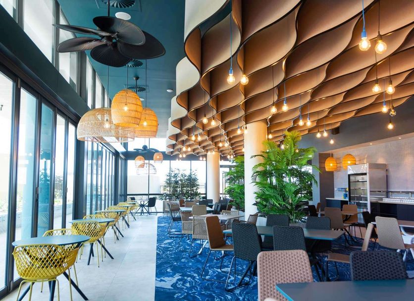 Rydges Gold Coast Airport in Bilinga, airy restaurant with ocean-inspired ceiling and large windows