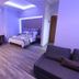 Hotel Mallas in Nea Kallikratia: modern room with bed, desk, sofa, and purple ambient lighting
