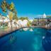 Hotel Paraiso Kora in San Blas features a blue outdoor pool with palm trees and a covered patio area.