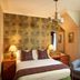 Loch Kinord Hotel in Aboyne bedroom with plaid bed, armchair, desk and window view