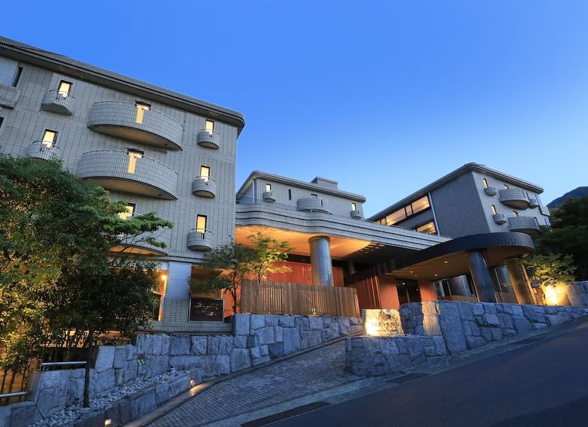 Merveille Hakone Gora in Hakone, exterior at dusk with stone wall, lit windows, and sloped driveway