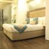 Hotel Centre Point Nagpur guest room with king bed, teal accents, and frosted glass bathroom door