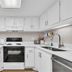 Pinnacle Port A-305 in Panama City Beach kitchen with white cabinets, stove, sink, microwave and dishwasher