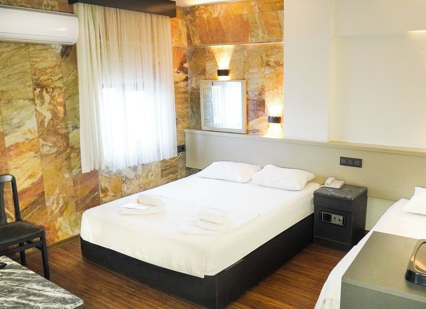 Hotel Guleryuz in Antalya guest room with two beds, wall lights, air conditioning, and a kettle tray