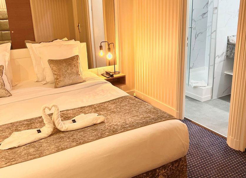 Maison Lutetia R Strasbourg guest room with king bed, bedside lamp and open bathroom door