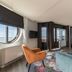 Leonardo Hotel Ijmuiden Seaport Beach room with bay window, seating area and bed with sea view in IJmuiden