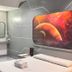Astrotel Cubao in Quezon City room with space-themed wall art, bed, desk, and mirror