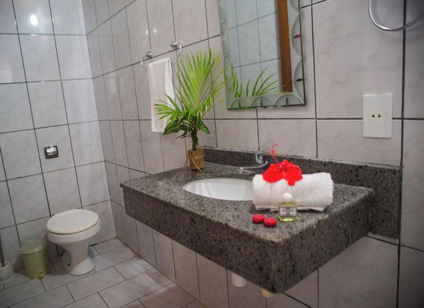 Pousada Velha Boipeba bathroom with granite sink, toilet, tiled walls and a vanity mirror