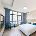 Zhoushan Dinghai New Donggang Hotel room with bed, chairs, and city view in Zhoushan