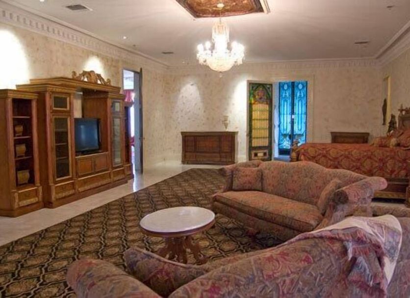 Dansereau House in Thibodaux guest room with chandelier, sofa, armchair, TV cabinet and bed