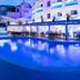Apartamentos Sal Rossa in Sant Josep de sa Talaia with a lit outdoor pool and beachfront terrace at dusk