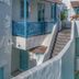 Resort De Paskani in Hua Hin with white-washed buildings, blue balcony, and stairway