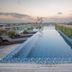 Nims Hotel Seminyak in Kuta rooftop infinity pool at sunset with glass railing and skyline view