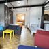 Homeplanet Hostel Leipzig room with sofa, bright yellow table, bunk bed and brick accent wall