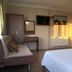 Vesta Apart Hotel Kusadasi room with bed, sofa, wall TV and sunlight on radiator