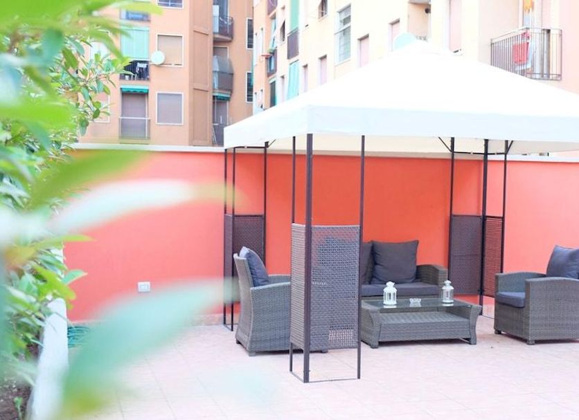 B&B I 10 Mondi Milan patio with white canopy, wicker seating and lounge chairs