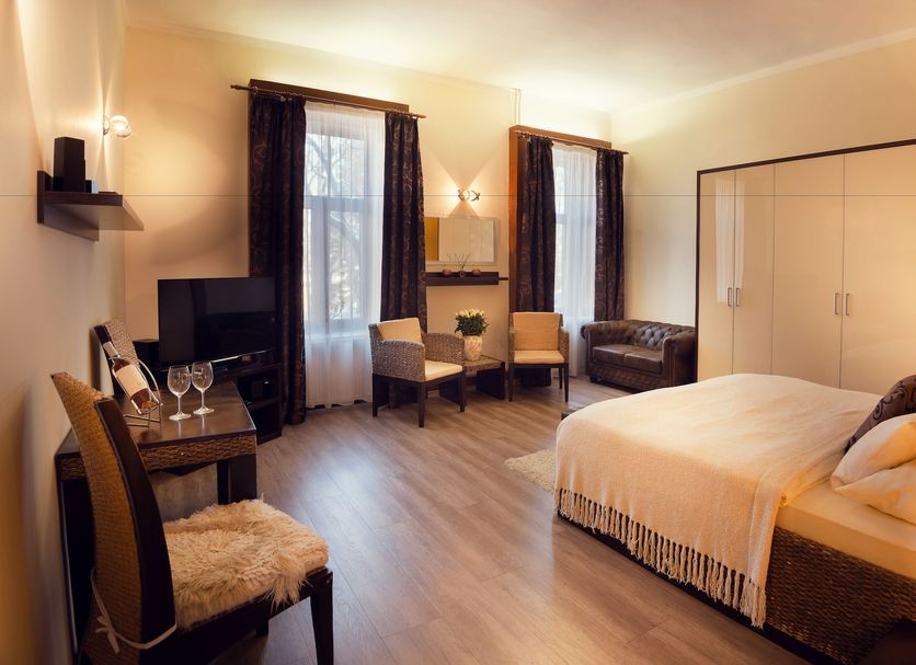 City Residence Apartment Hotel Košice room with bed, seating area, wardrobe, and TV